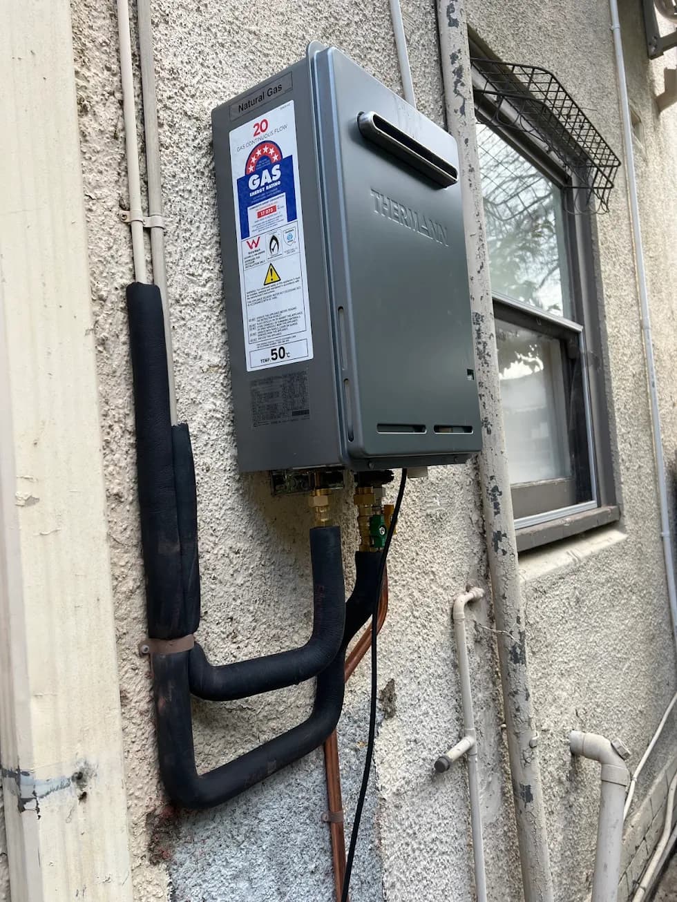 Wall-mounted gas hot water unit and insulated pipework